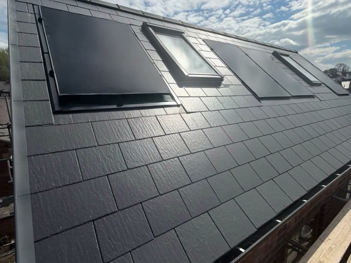 Finished natural slate roof with roof windows and integrated solar panels